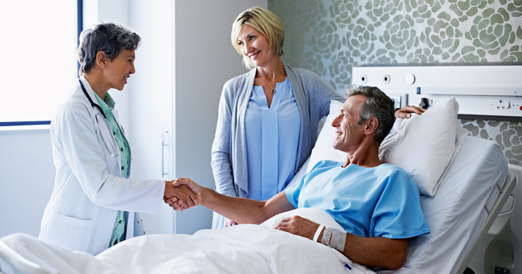 Cross-selling hospital indemnity plans image of person in hospital shaking hands with a doctor