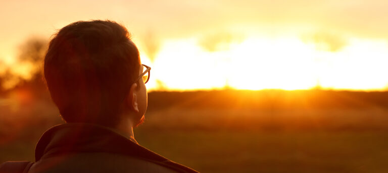 An image of a person gazing into the sunset looking for missed opportunities